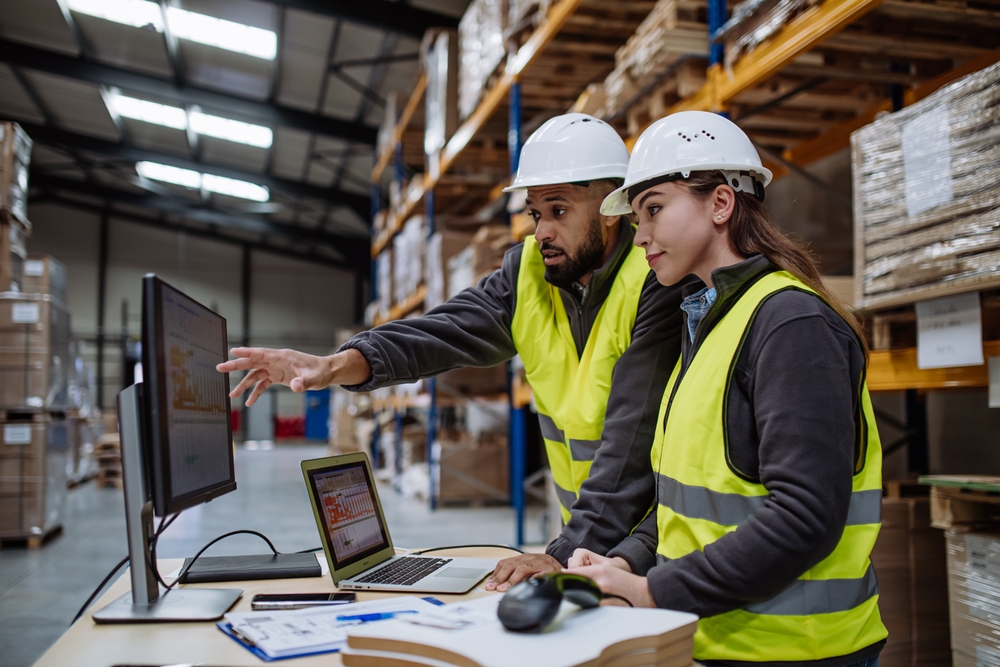 Zwei Mitarbeiter arbeiten zusammen im Lager mit einem WMS.