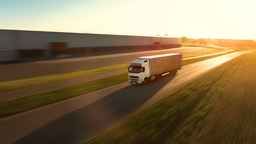 Ein LKW mit einen Lager im Hintergrund