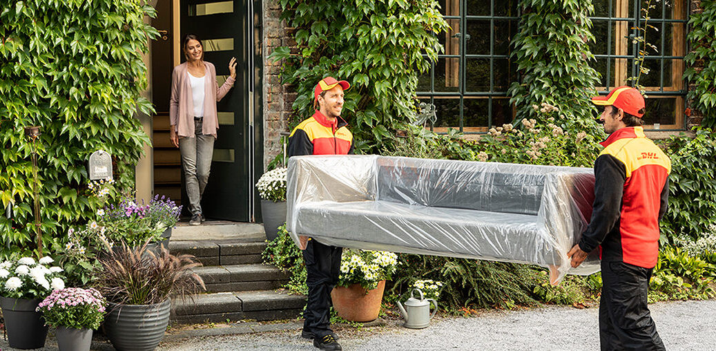 DHL 2 Mann-Handling Mitarbeiter tragen einen Sofa