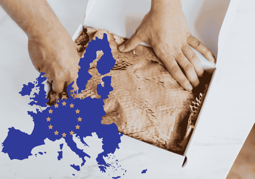 Auf dem Bild ist zu sehen, wie jemand Füllmaterial in ein Paket packt. Zu sehen ist auch die Flagge der Europäischen Union.